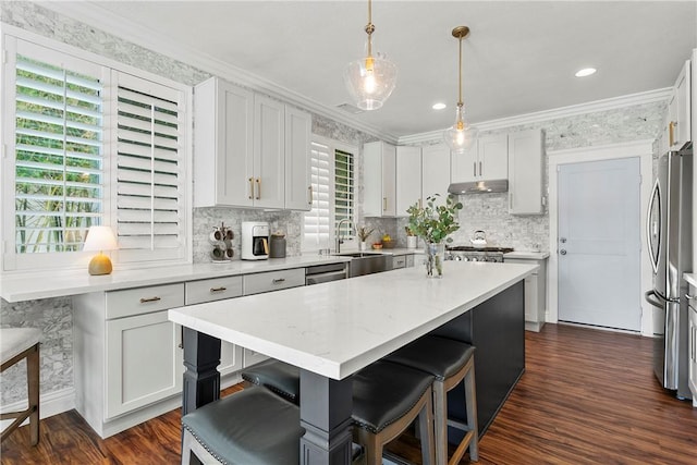 23763 Aspen, Murrieta, CA 92562 - kitchen with a kitchen bar, backsplash, dark wood-style floors, a center island, and appliances with stainless steel finishes