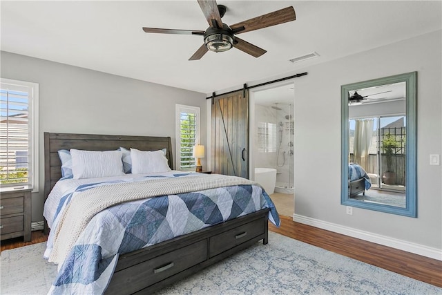 23763 Aspen, Murrieta, CA 92562 - bedroom featuring a barn door, wood finished floors, multiple windows, and connected bathroom