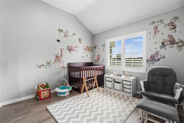 1867 W Falmouth Ave Unit 60, Anaheim, CA 92801 - bedroom with lofted ceiling, a crib, wood finished floors, and a textured ceiling