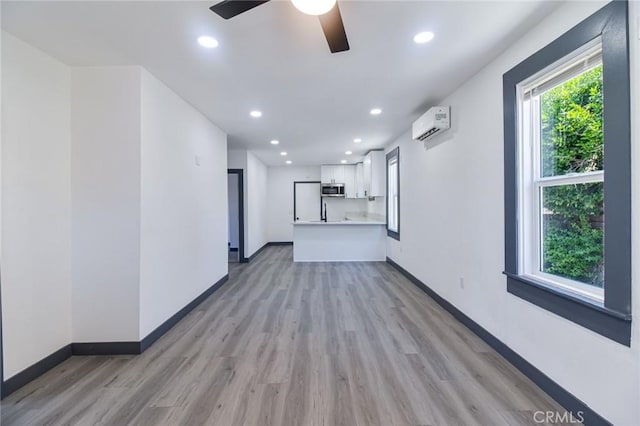 1235 Spruce St, San Bernardino, CA 92411 - unfurnished living room featuring light wood-style floors, ceiling fan, recessed lighting, and a wall mounted AC