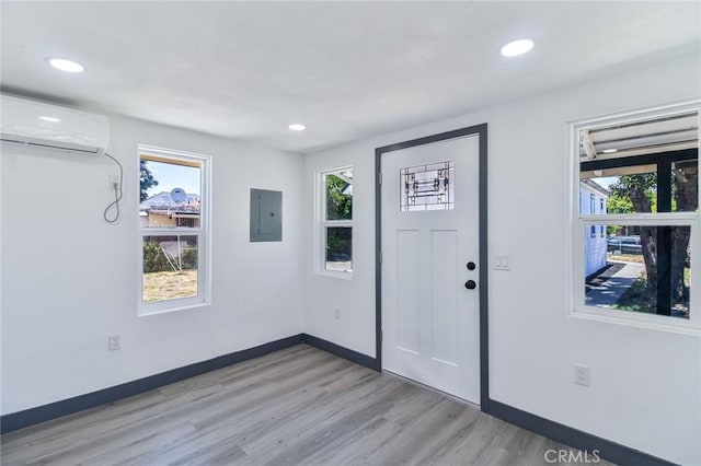 1235 Spruce St, San Bernardino, CA 92411 - entrance foyer featuring electric panel, a wall unit AC, light wood-type flooring, and recessed lighting