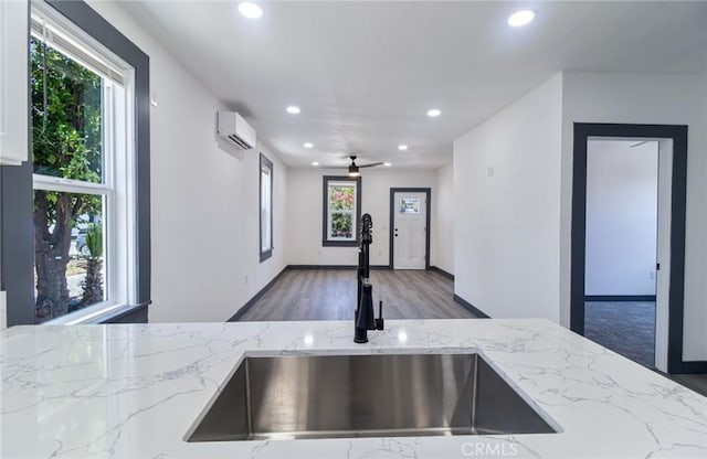 1235 Spruce St, San Bernardino, CA 92411 - kitchen featuring an AC wall unit, recessed lighting, light stone counters, a ceiling fan, and wood finished floors