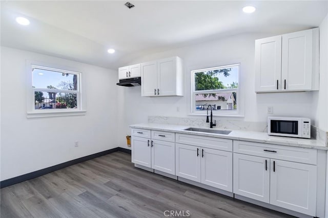 1235 Spruce St, San Bernardino, CA 92411 - kitchen featuring white microwave, white cabinetry, recessed lighting, light stone countertops, and wood finished floors