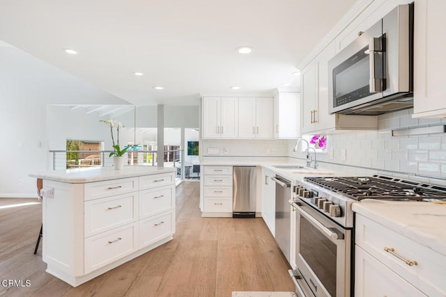 5040 Island View St, Oxnard, CA 93035 - kitchen with stainless steel appliances, light wood finished floors, backsplash, white cabinetry, and recessed lighting