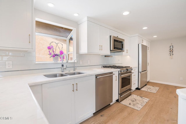 5040 Island View St, Oxnard, CA 93035 - kitchen featuring appliances with stainless steel finishes, white cabinets, tasteful backsplash, light wood-style floors, and recessed lighting