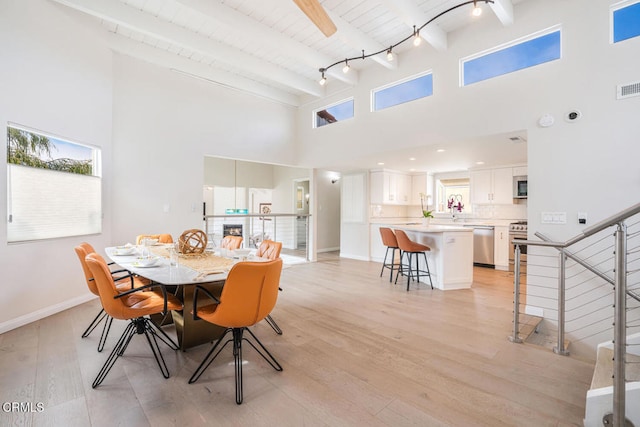 5040 Island View St, Oxnard, CA 93035 - dining room featuring a towering ceiling, light wood-style flooring, a wooden ceiling with exposed beams, and stairs