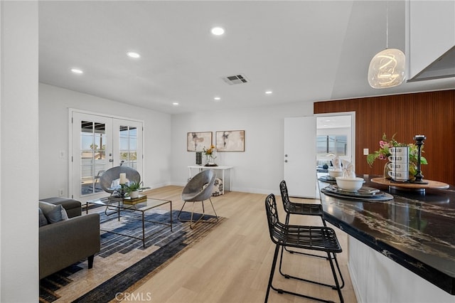 5676 Aztec Ave Unit 29, Palms, CA 92277 - living room featuring recessed lighting, light wood finished floors, french doors, and wooden walls