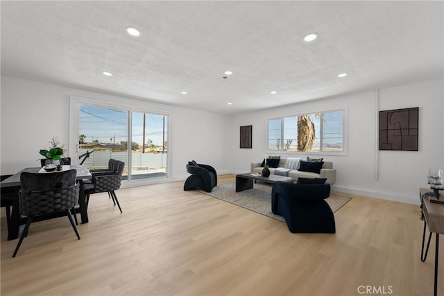 5676 Aztec Ave Unit 29, Palms, CA 92277 - living area featuring light wood finished floors, healthy amount of natural light, recessed lighting, and a textured ceiling