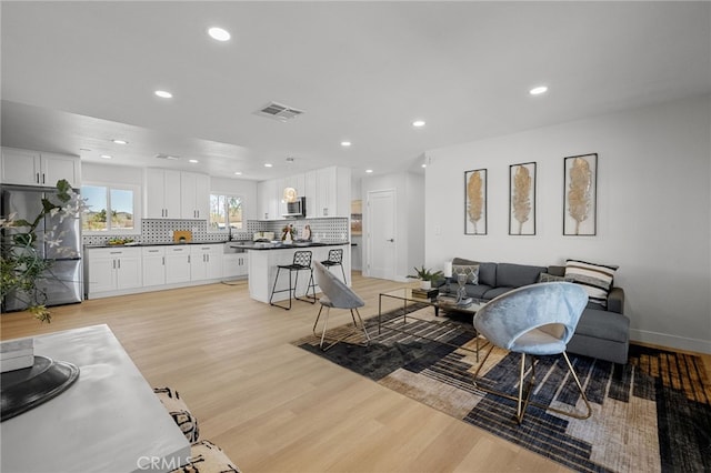 5676 Aztec Ave Unit 29, Palms, CA 92277 - living area with light wood-style flooring and recessed lighting