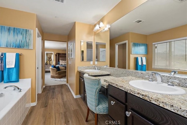 4106 Irish Moss Ln, San Bernardino, CA 92407 - bathroom featuring double vanity, wood finished floors, a bath, and connected bathroom