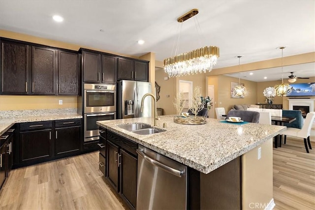 4106 Irish Moss Ln, San Bernardino, CA 92407 - kitchen with stainless steel appliances, light wood-style flooring, open floor plan, hanging light fixtures, and recessed lighting