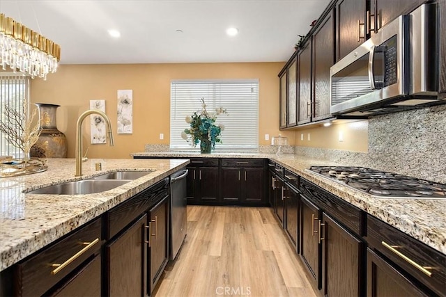 4106 Irish Moss Ln, San Bernardino, CA 92407 - kitchen featuring stainless steel appliances, light wood-style flooring, recessed lighting, light stone counters, and decorative light fixtures