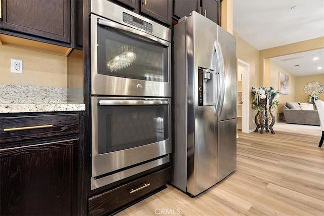 4106 Irish Moss Ln, San Bernardino, CA 92407 - kitchen with stainless steel appliances, dark brown cabinetry, light wood-style floors, and open floor plan