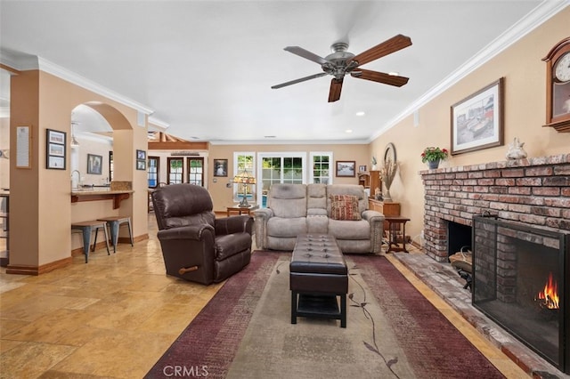 25572 Orchard Rim Ln, Lake Forest, CA 92630 - living room featuring a brick fireplace, a ceiling fan, ornamental molding, arched walkways, and recessed lighting
