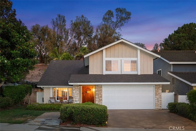 25572 Orchard Rim Ln, Lake Forest, CA 92630 - view of front of house with stone siding, an attached garage, concrete driveway, and board and batten siding