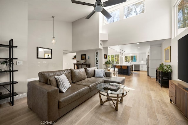 24932 Dove Tree Ln, Lake Forest, CA 92630 - living area with a towering ceiling, a ceiling fan, and light wood-type flooring