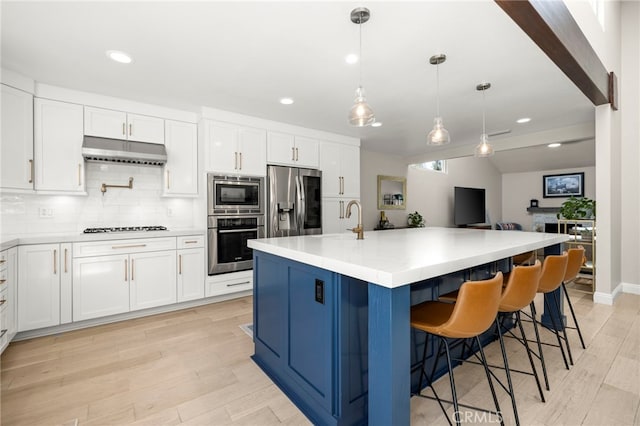 24932 Dove Tree Ln, Lake Forest, CA 92630 - kitchen with appliances with stainless steel finishes, under cabinet range hood, light wood-style floors, white cabinets, and recessed lighting