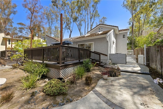 24932 Dove Tree Ln, Lake Forest, CA 92630 - rear view of property featuring stucco siding, a wooden deck, and a gate