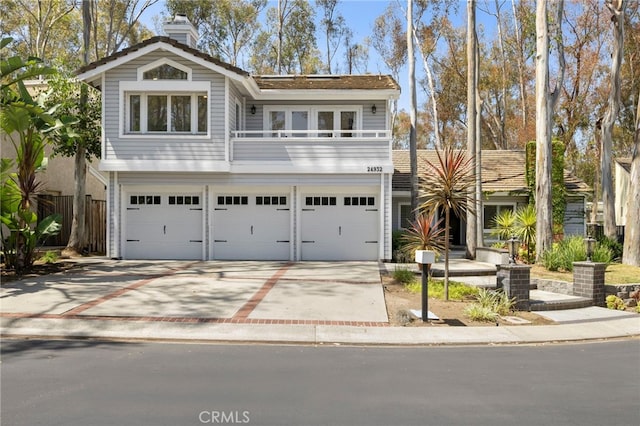 24932 Dove Tree Ln, Lake Forest, CA 92630 - view of front of property featuring concrete driveway, an attached garage, a chimney, and a balcony