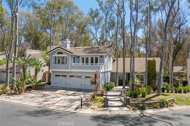 24932 Dove Tree Ln, Lake Forest, CA 92630 - view of front of house featuring a garage, driveway, a chimney, and a balcony