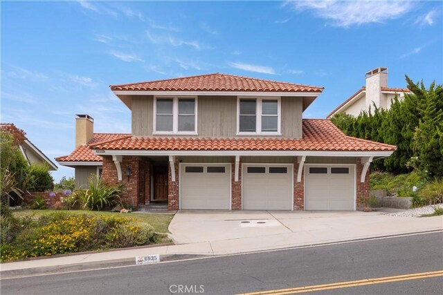 6935 Verde Ridge Rd, Rancho Palos Verdes, CA 90275 - mediterranean / spanish-style home with a tiled roof, concrete driveway, brick siding, and a porch