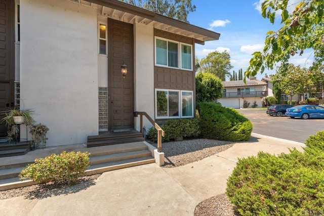 17177 Bernardo Center Dr, San Diego, CA 92128 - doorway to property featuring stucco siding and uncovered parking