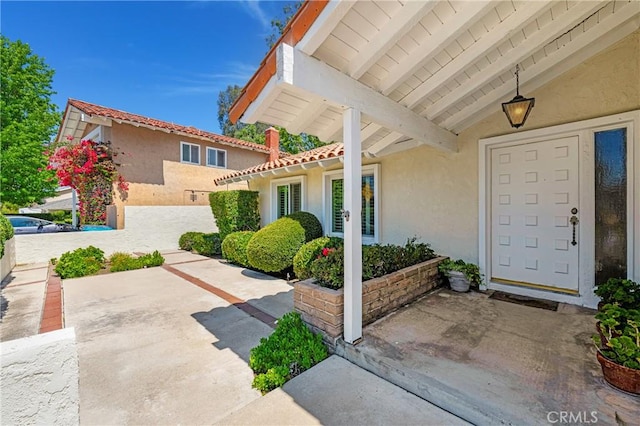 26501 Cortina Dr, Mission Viejo, CA 92691 - doorway to property featuring stucco siding, a patio area, and a tile roof