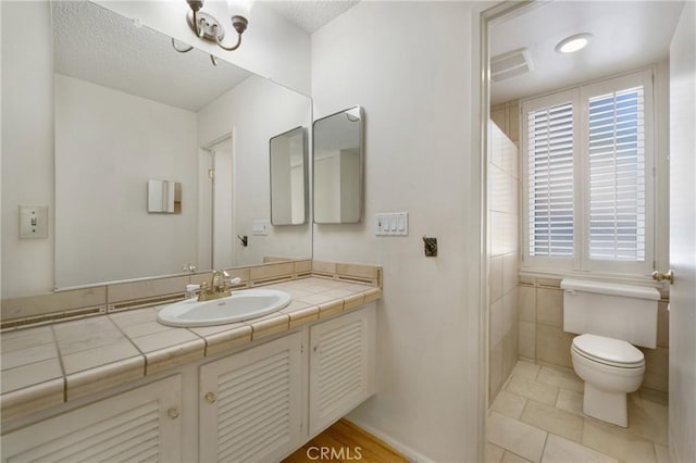 26501 Cortina Dr, Mission Viejo, CA 92691 - bathroom with vanity, healthy amount of natural light, a textured ceiling, and tile patterned floors