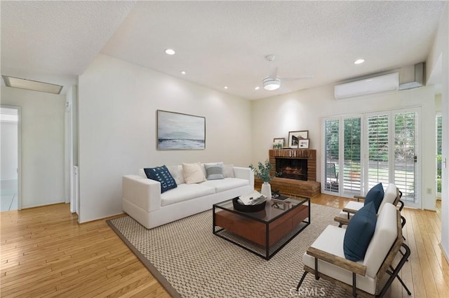 26501 Cortina Dr, Mission Viejo, CA 92691 - living area with a wall mounted AC, light wood-style flooring, a ceiling fan, a brick fireplace, and recessed lighting