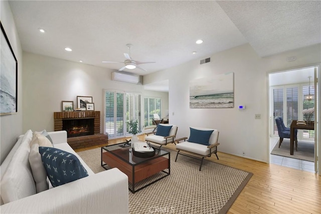 26501 Cortina Dr, Mission Viejo, CA 92691 - living area with light wood-style flooring, a fireplace, recessed lighting, a wall mounted AC, and a ceiling fan