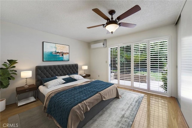 26501 Cortina Dr, Mission Viejo, CA 92691 - bedroom with a wall unit AC, access to outside, wood finished floors, a textured ceiling, and a ceiling fan
