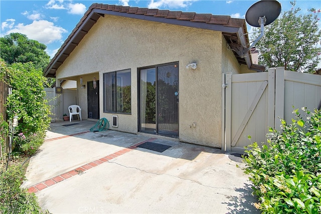 5050 Canyon Crest Dr Unit 5, Riverside, CA 92507 - rear view of house featuring stucco siding, a gate, and a patio area