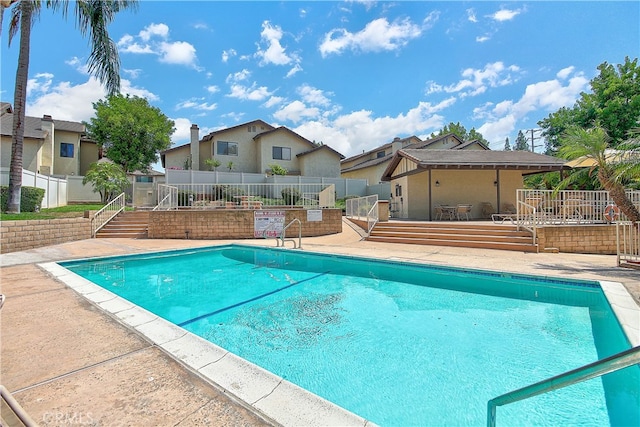 5050 Canyon Crest Dr Unit 5, Riverside, CA 92507 - community pool with a fenced backyard, a residential view, a wooden deck, and a patio