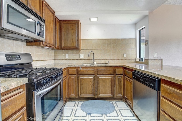 5050 Canyon Crest Dr Unit 5, Riverside, CA 92507 - kitchen featuring stainless steel appliances, brown cabinets, tasteful backsplash, and light countertops
