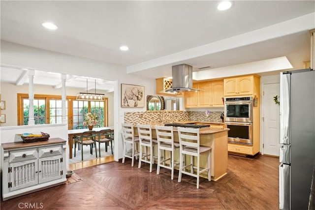 2240 La Sierra Way, Claremont, CA 91711 - kitchen with appliances with stainless steel finishes, island exhaust hood, a peninsula, a breakfast bar area, and decorative backsplash