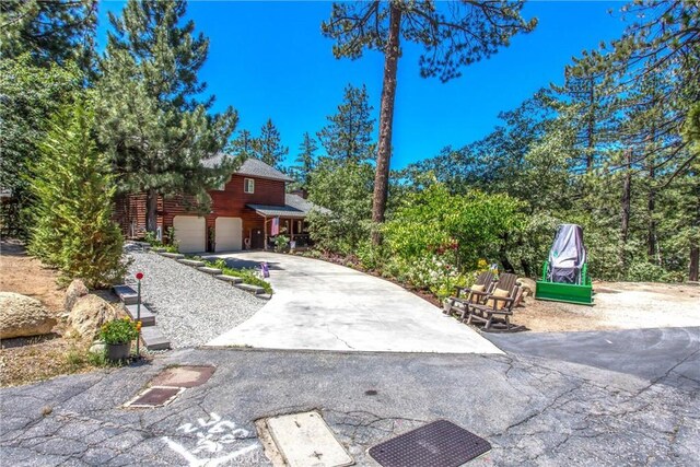 32425 Snowshoe Ln, Running Springs, CA 92382 - view of yard with an attached garage and concrete driveway