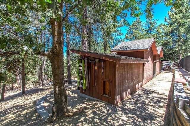 32425 Snowshoe Ln, Running Springs, CA 92382 - view of side of home featuring roof with shingles and an outdoor structure