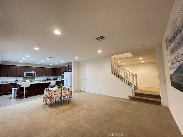 12639 Spruce Hill Rd, Moreno Valley, CA 92555 - dining space featuring light carpet, recessed lighting, and stairs