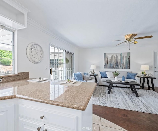 415 Buttonwood Dr, Brea, CA 92821 - kitchen with healthy amount of natural light, crown molding, a ceiling fan, white cabinets, and a peninsula