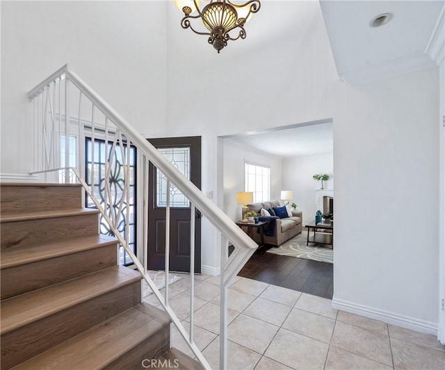 415 Buttonwood Dr, Brea, CA 92821 - stairway featuring tile patterned floors, a high ceiling, a chandelier, and ornamental molding
