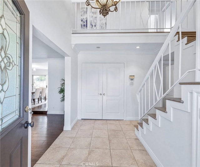 415 Buttonwood Dr, Brea, CA 92821 - entryway featuring a high ceiling, stairway, crown molding, light tile patterned flooring, and a chandelier
