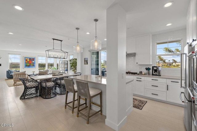 1437 Windshore Way, Oxnard, CA 93035 - kitchen featuring a breakfast bar, recessed lighting, light countertops, decorative backsplash, and white cabinetry