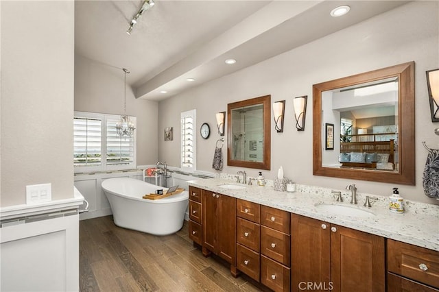 3602 E Ridgeway Rd, Orange, CA 92867 - bathroom with a soaking tub, double vanity, vaulted ceiling, recessed lighting, and wood finished floors