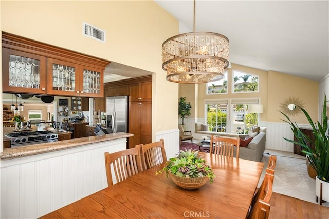 3602 E Ridgeway Rd, Orange, CA 92867 - dining space featuring a wainscoted wall, wood finished floors, and high vaulted ceiling