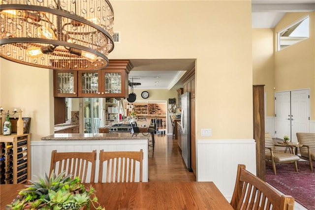 3602 E Ridgeway Rd, Orange, CA 92867 - dining area featuring wainscoting, a towering ceiling, and wood finished floors