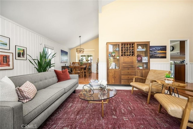 3602 E Ridgeway Rd, Orange, CA 92867 - living area with wainscoting, high vaulted ceiling, a decorative wall, and wood finished floors