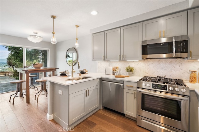 29416 Port Royal Way, Laguna Niguel, CA 92677 - kitchen with stainless steel appliances, gray cabinetry, a peninsula, wood finished floors, and recessed lighting