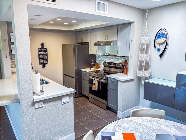 1111 E Ramon Rd Unit 37, Palm Springs, CA 92264 - kitchen with stainless steel appliances, under cabinet range hood, gray cabinets, and decorative backsplash