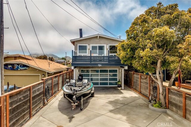 1164 12th St, Los Osos, CA 93402 - view of front facade featuring stucco siding, driveway, a garage, and a balcony