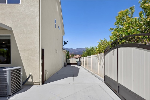 102 Mesa Ct, Calimesa, CA 92320 - view of side of property featuring stucco siding, a mountain view, a gate, and a patio area